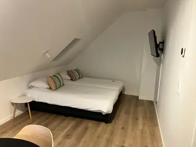 a small room with two beds in a attic at Hotel De Groene Hendrickx in Hasselt