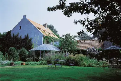 a yard with a table and chairs and a barn at Orshof in Oudsbergen
