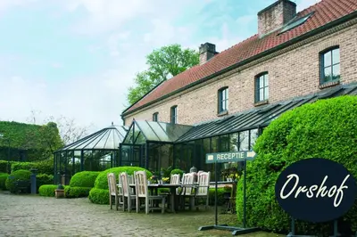 a table and chairs in front of a building at Orshof in Oudsbergen