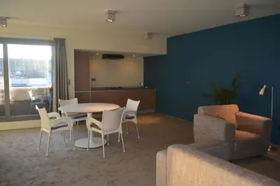 a living room with a table and chairs and a couch at Appartroom Hasselt in Hasselt