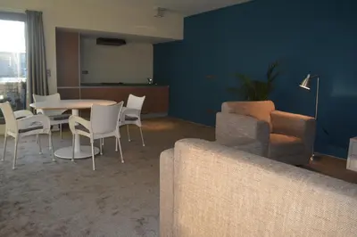a living room with a table and chairs and a couch at Appartroom Hasselt in Hasselt