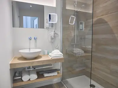 a bathroom with a sink and a shower at Hotel Restaurant De Kommel in Voeren