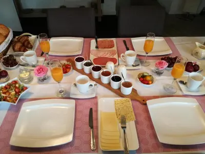 a table with plates of food and glasses of orange juice at La Rose in Overpelt