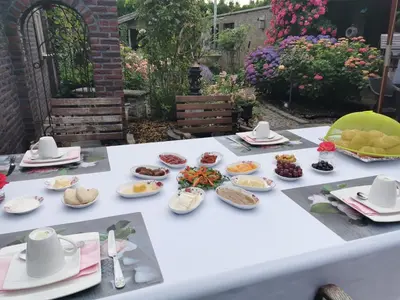a white table with plates of food on it at La Rose in Overpelt
