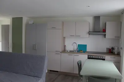 a kitchen with white cabinets and a table and a counter at Logie Rotem in Dilsen-Stokkem