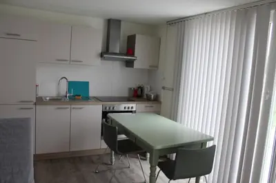 a kitchen with a table and chairs and a sink at Logie Rotem in Dilsen-Stokkem