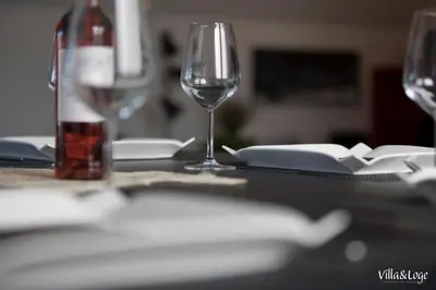 a table with a wine glass and a bottle of wine at Villa&Loge in Lontzen