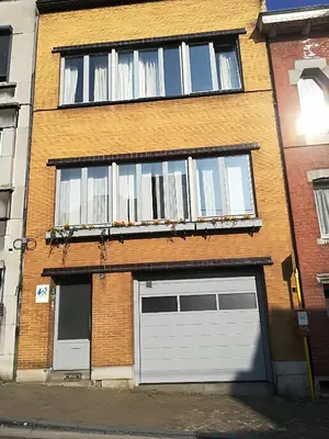 a brick building with two garage doors and windows at W'allons nous dormir in Liège