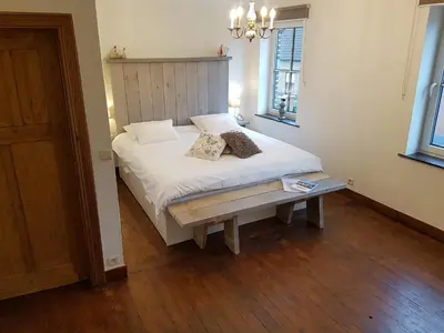 a bedroom with a white bed and a wooden floor at Widdingenhof in Wellen
