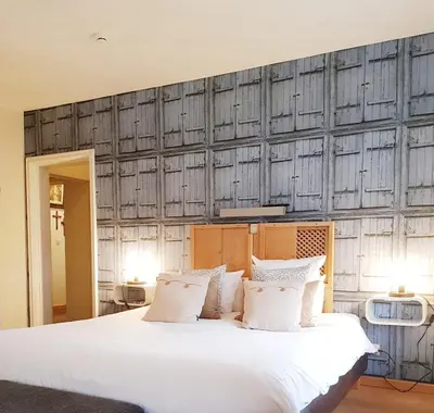 a bedroom with a large bed with white pillows at Hotel Au Nom De Dieu in Dilsen-Stokkem