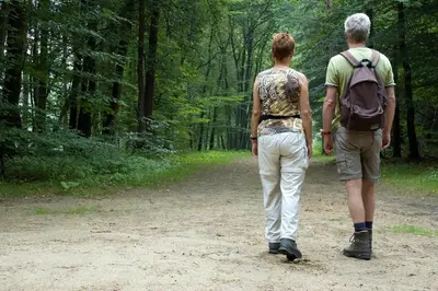 two men walking down a dirt path in the woods at Vakantiepark Wilhelm Tell Vakantieappartement in Oudsbergen