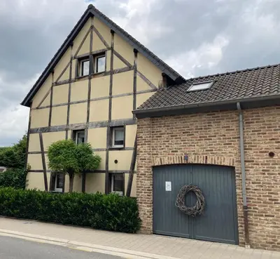 an old building with a garage and a wreath on it at 'tMaelhof in Voeren