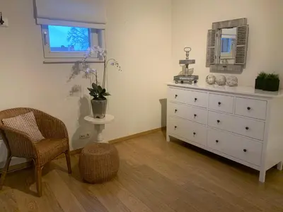 a bedroom with a dresser and a chair and a window at 'tMaelhof in Voeren