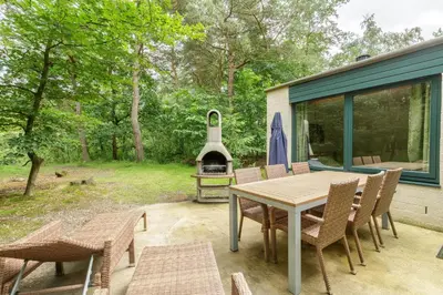 a patio with a table and chairs and a grill at Center Parcs Vossemeren in Lommel
