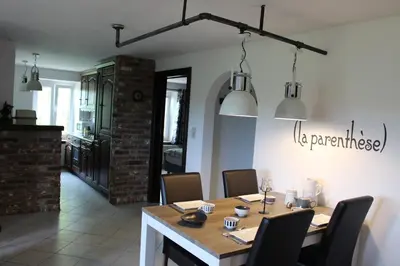 a dining room with a wooden table and chairs at (La parenthese) in Hombourg