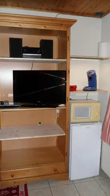 a wooden shelf with a microwave in a kitchen at gasthof lederhose in Diepenbeek
