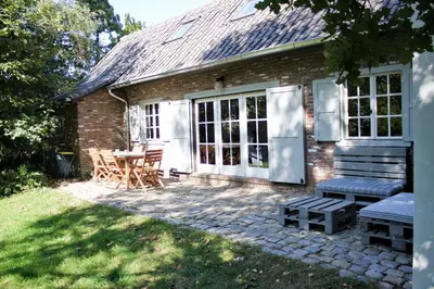 a brick house with a patio with a table and chairs at De Hoog Weyen in Halen