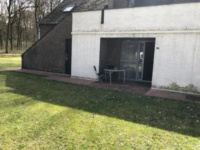 a brick building with a patio with a table in it at Ceder 9 Hengelhoef in Houthalen-Helchteren