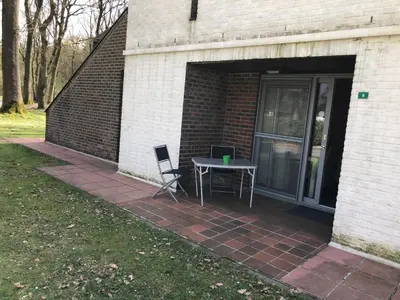 a patio with a table and a chair in a garage at Ceder 9 Hengelhoef in Houthalen-Helchteren