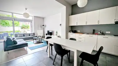 a kitchen and living room with a table and chairs at Augustins in Liège