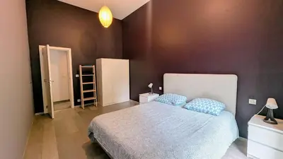 a bedroom with a large bed with blue pillows at Augustins in Liège
