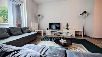 a living room with a couch and a tv at Augustins in Liège