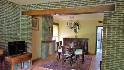 a dining room with a table and a brick wall at De Stille Weier in Genk