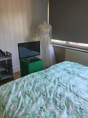 a wedding dress hanging in a room with a bed at Au 194 in Liège