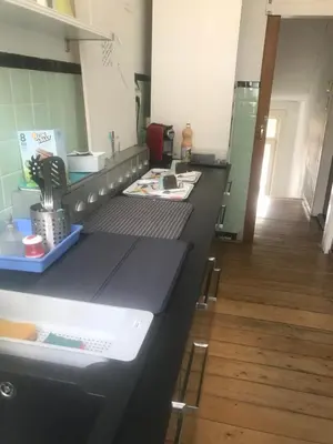 a kitchen with a black counter and a wooden floor at Au 194 in Liège