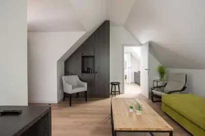 a living room with a green couch and a table at B&B Sasput in Hasselt
