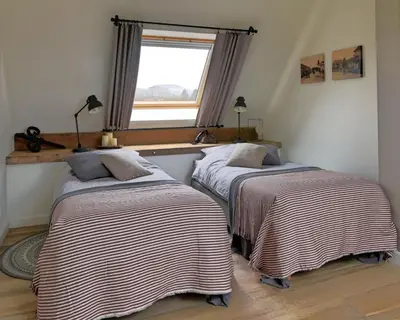 two beds in a room with a window at B&B Eikenlaan 12 in Genk