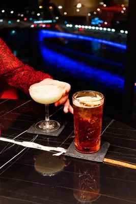 a person holding a margarita and a drink on a table at Van der Valk Hotel Liège Congres in Liège