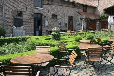 a patio with tables and chairs in front of a building at Het Pachthof in Borlo
