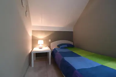a small bedroom with a bed and a side table at Stefjes Holiday Home in Dilsen-Stokkem