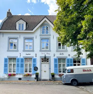 a van parked in front of a white house at Gastenkamers In de Bleick in Rekem