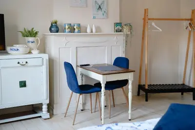 a room with a table and two blue chairs at Gastenkamers In de Bleick in Rekem