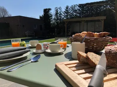 a picnic table with bread and a basket of food at B&B Maris Logies in Hasselt