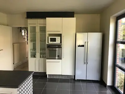 a kitchen with a refrigerator and a microwave at Vakantiehuis Piantho in Overpelt