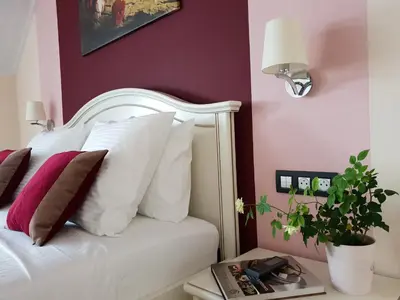 a bedroom with a white bed with purple walls at B&B Secret Garden Adults only in Voeren