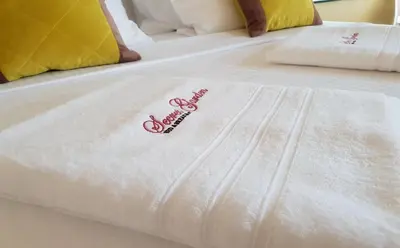 a white bedsheet with a pink ribbon on it at B&B Secret Garden Adults only in Voeren