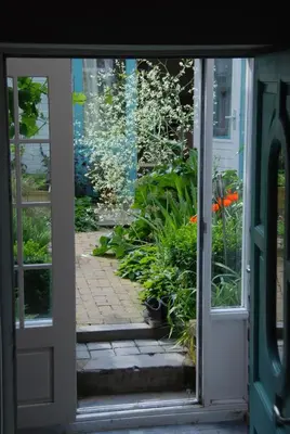 an open door with a view of a garden at Staying with the artist in Teuven