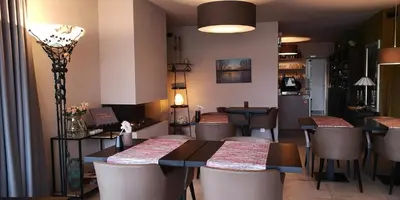 a restaurant with tables and chairs in a room at B&B de Taller-Hoeve in Maasmechelen