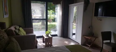a living room with a couch and a sliding glass door at B&B 't Goedhof in Maaseik