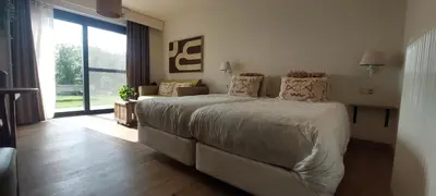 a bedroom with a large bed and a large window at B&B 't Goedhof in Maaseik
