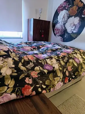 a bed in a room with a floral bedspread at Casa Roman - nieuwe vakantiewoning - Deluxe 4p - Relax 4p - Comfort 4p -- ---Cosy 2p in Zonhoven