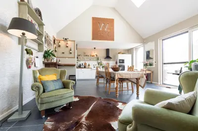 a living room with green chairs and a table at B&B Woods and Wine in As