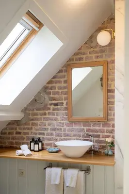 a bathroom with a sink and a brick wall at B&B Woods and Wine in As