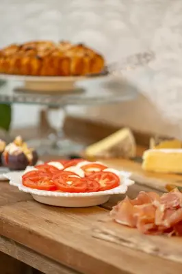 a table with a plate of tomatoes on a cutting board at B&B Woods and Wine in As