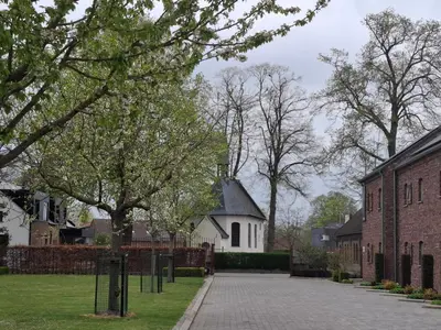 a street in a neighborhood with a white church at Hotel Oude Eycke in Maaseik