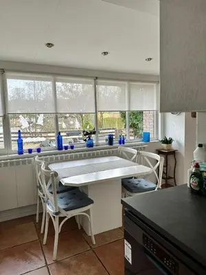 a kitchen with a table and chairs and windows at Holiday Home 'Beautifull Water' in Lanaken